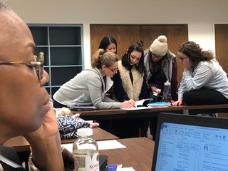 a group of young people reading the African American Registry