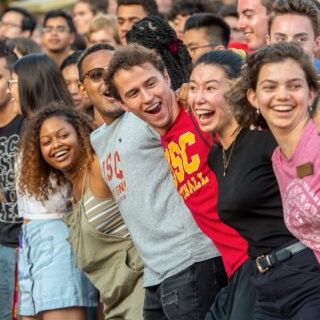 group of students linked in line, laughing together