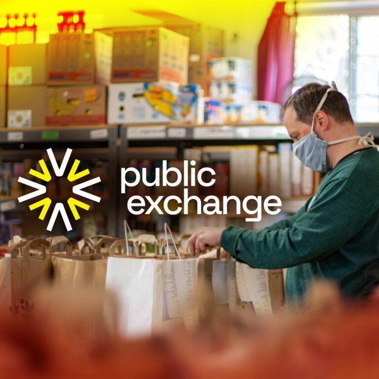 Man wearing a mask while sorting through food at a food pantry. On top of the image is the Public Exchange Logo featuring a yellow sunburst design