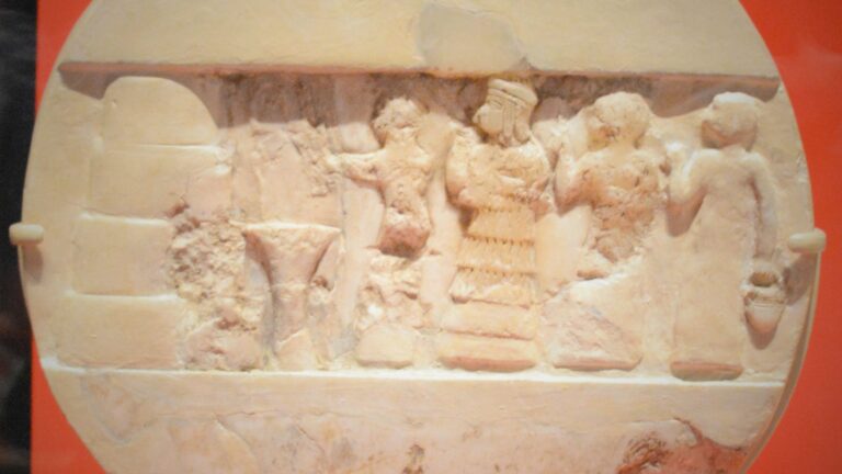 Ancient alabaster disk carved with Sumerian religious figures