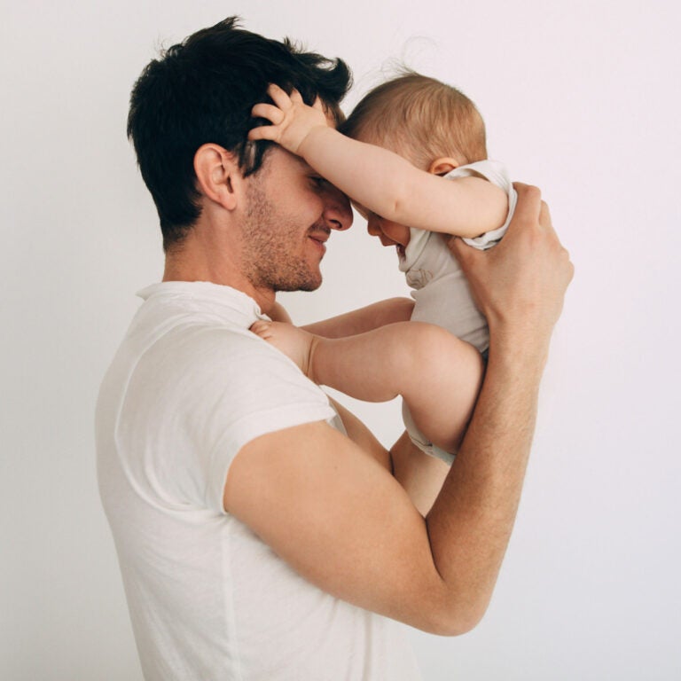 A father holds up his baby