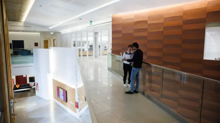 Two USC students inside a building on the 2nd floor, discussing their research.
