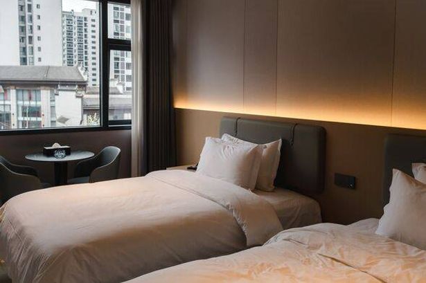 Modern hotel room with twin beds and city view