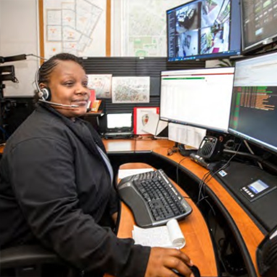 Person with headset at a multiscreen computer workstation